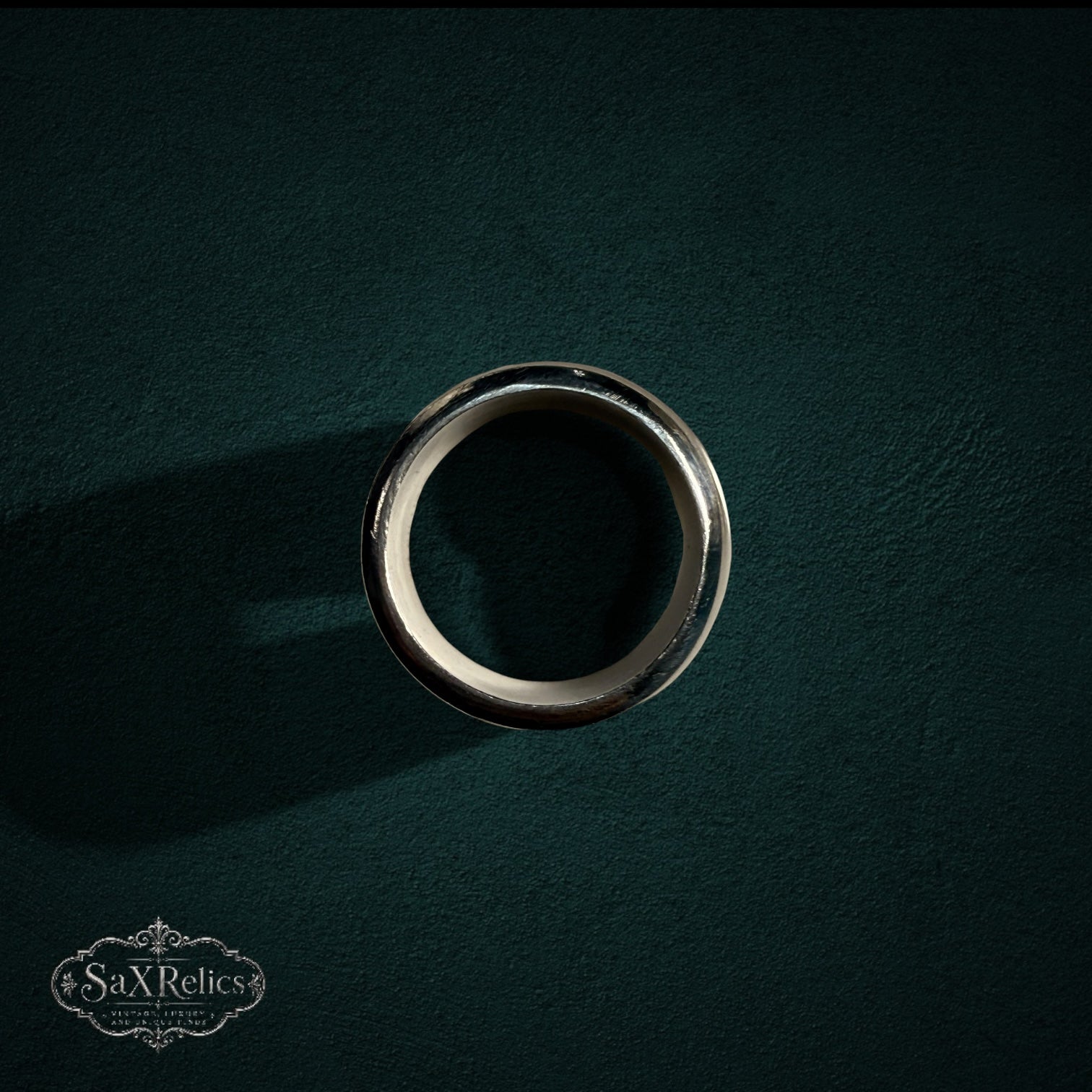 My Store polished sterling silver wide band ring with a smooth, curved silhouette on a dark textured background.