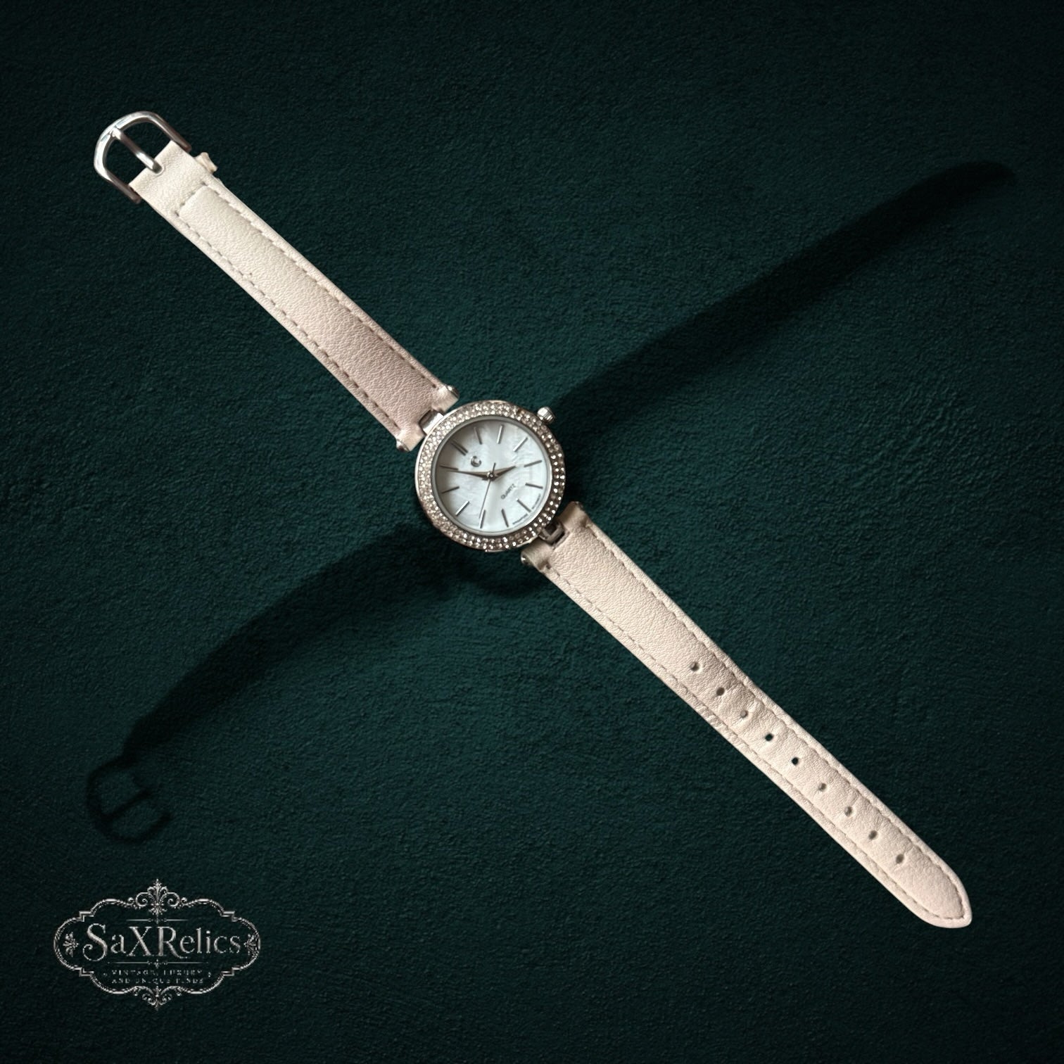 My Store elegant quartz wristwatch with a light beige leather strap and a crystal-encrusted bezel on a dark background
