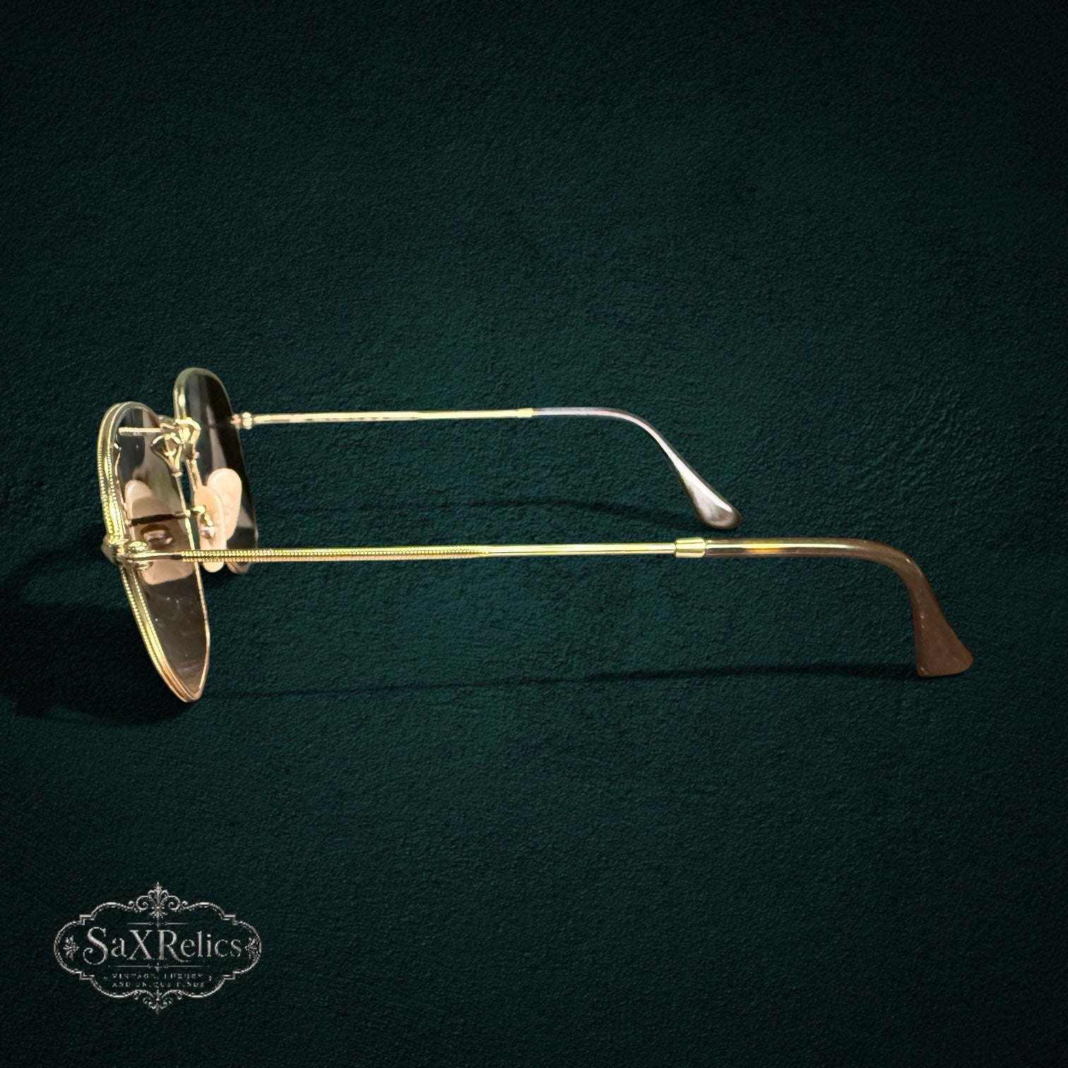 My Store Ray-Ban polarized sunglasses with a gold-tone metal geometric frame and brown temple tips, side view.