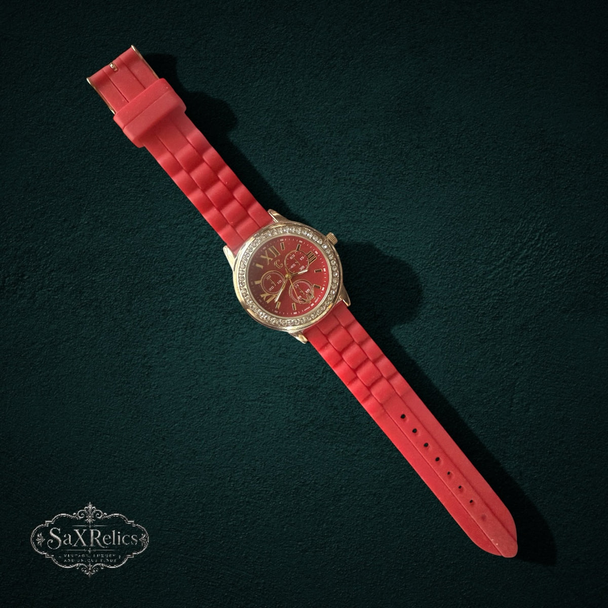 My Store red silicone strap watch with gold-tone case, crystal-encrusted bezel, and red dial on dark background