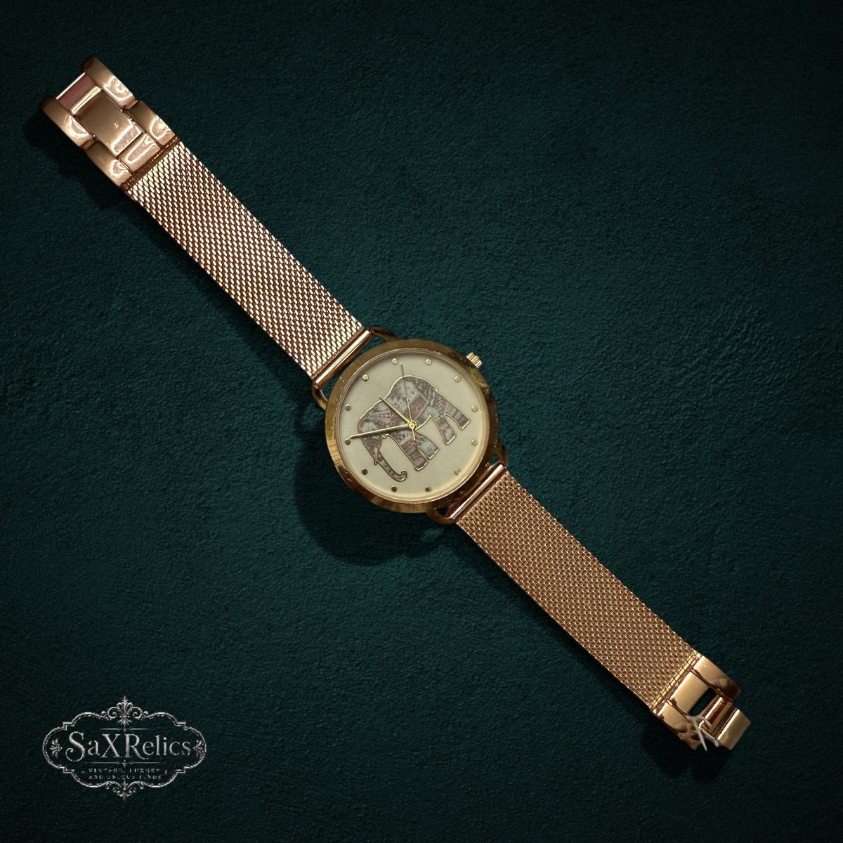 My Store rose gold analog wristwatch with a mesh strap and an intricate elephant motif on the dial.