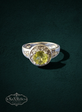 My Store round-cut yellow-green gemstone halo ring in a polished silver-tone setting with accent stones.