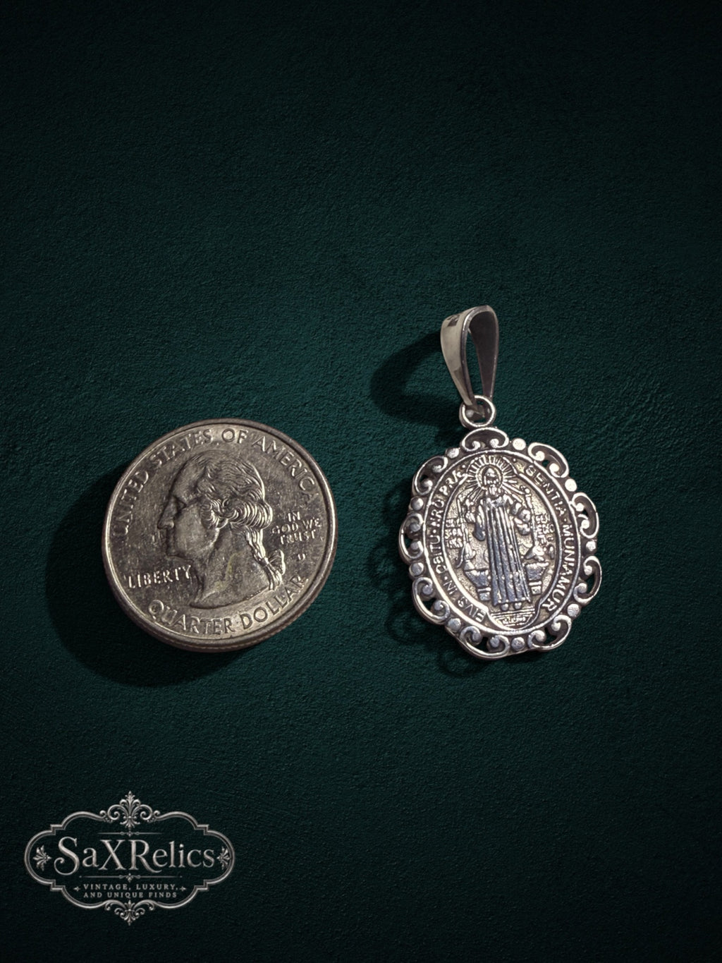 Benito sterling silver Saint Benedict pendant next to a US quarter for size