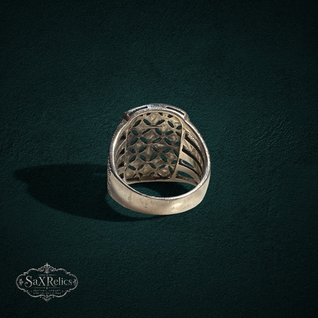 My Store SAXRelics silver statement ring with intricate openwork filigree and ribbed band design on dark background.