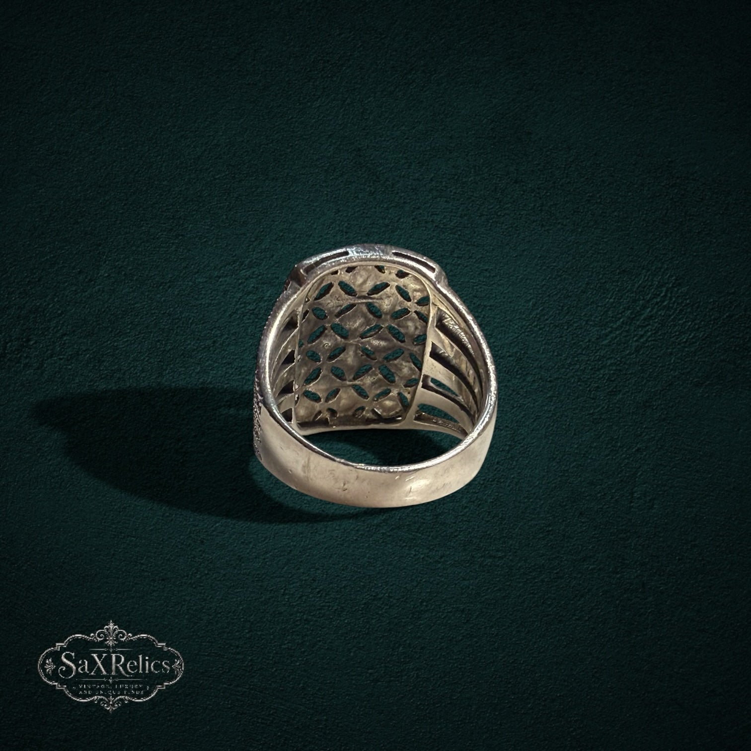 My Store SAXRelics silver statement ring with intricate openwork filigree and ribbed band design on dark background.
