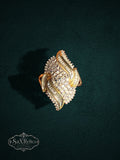 My Store SAXRelics ornate gold statement ring with brilliant and baguette-cut stones on a dark textured background