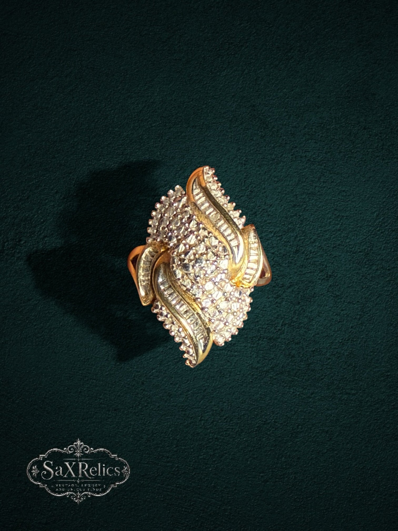 My Store SAXRelics ornate gold statement ring with brilliant and baguette-cut stones on a dark textured background
