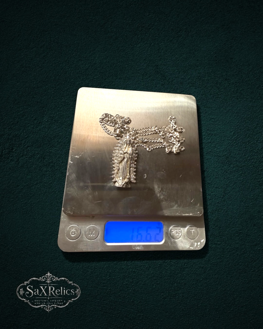 SaX Relics sterling silver Our Lady of Guadalupe pendant necklace with curb chain on a digital scale