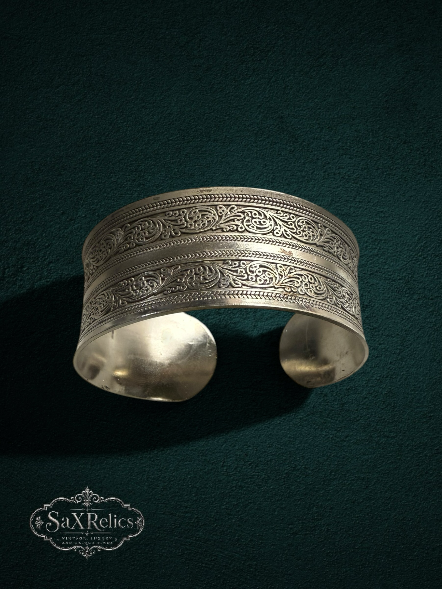 My Store SaXRelics silver wide cuff bracelet with intricate floral engravings and an adjustable open-back design.