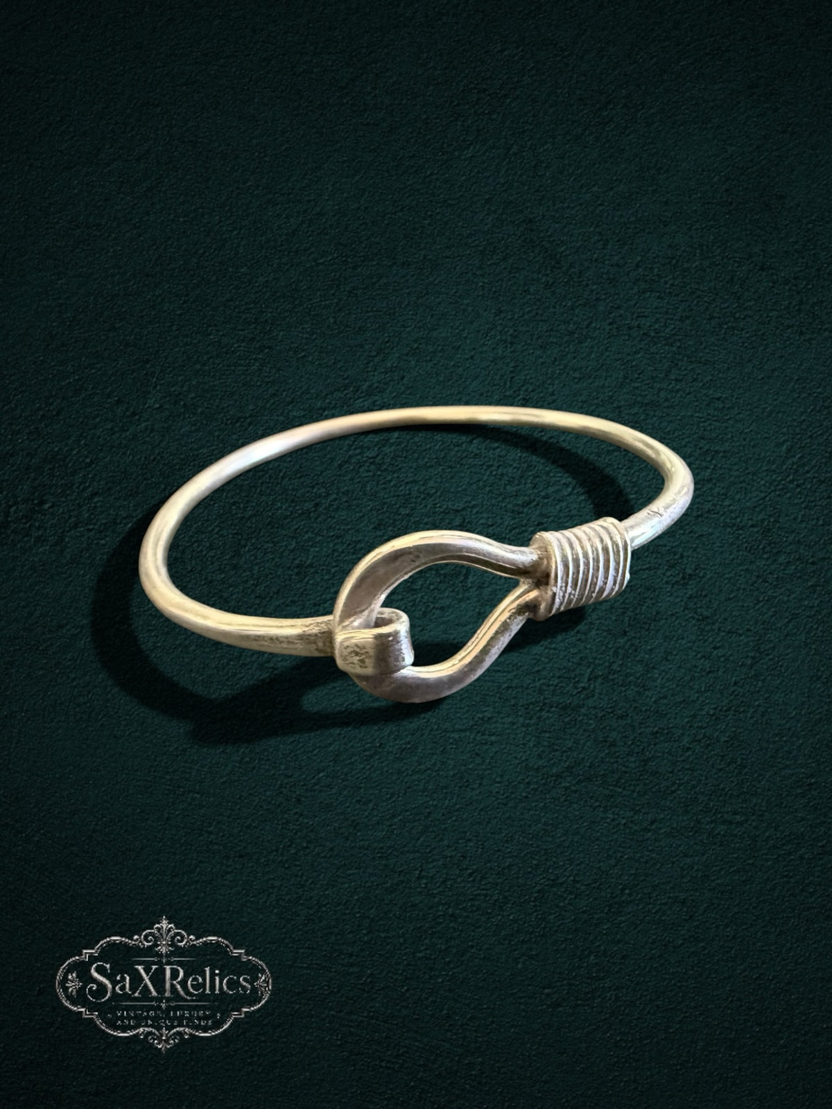 My Store SaxRelics sterling silver hook bangle bracelet with wire-wrapped detail on a dark textured background.