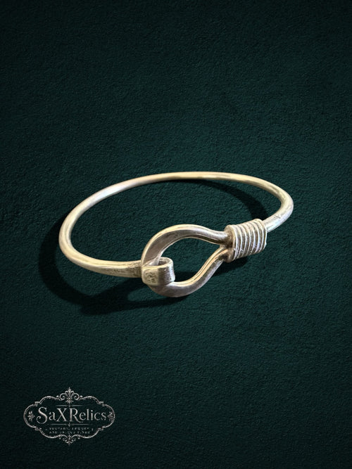 My Store SaxRelics sterling silver hook bangle bracelet with wire-wrapped detail on a dark textured background.