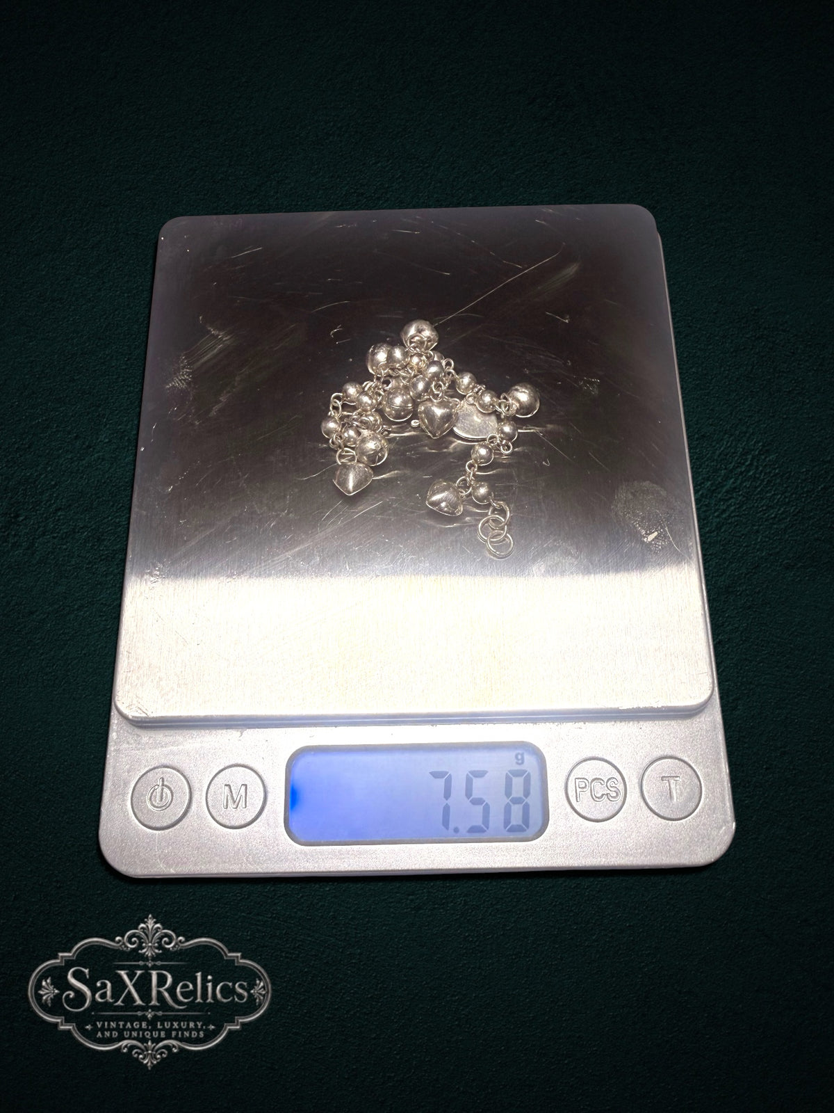 My Store SAXRelics sterling silver heart charm bracelet with polished spheres on a digital scale weighing 7.58 grams
