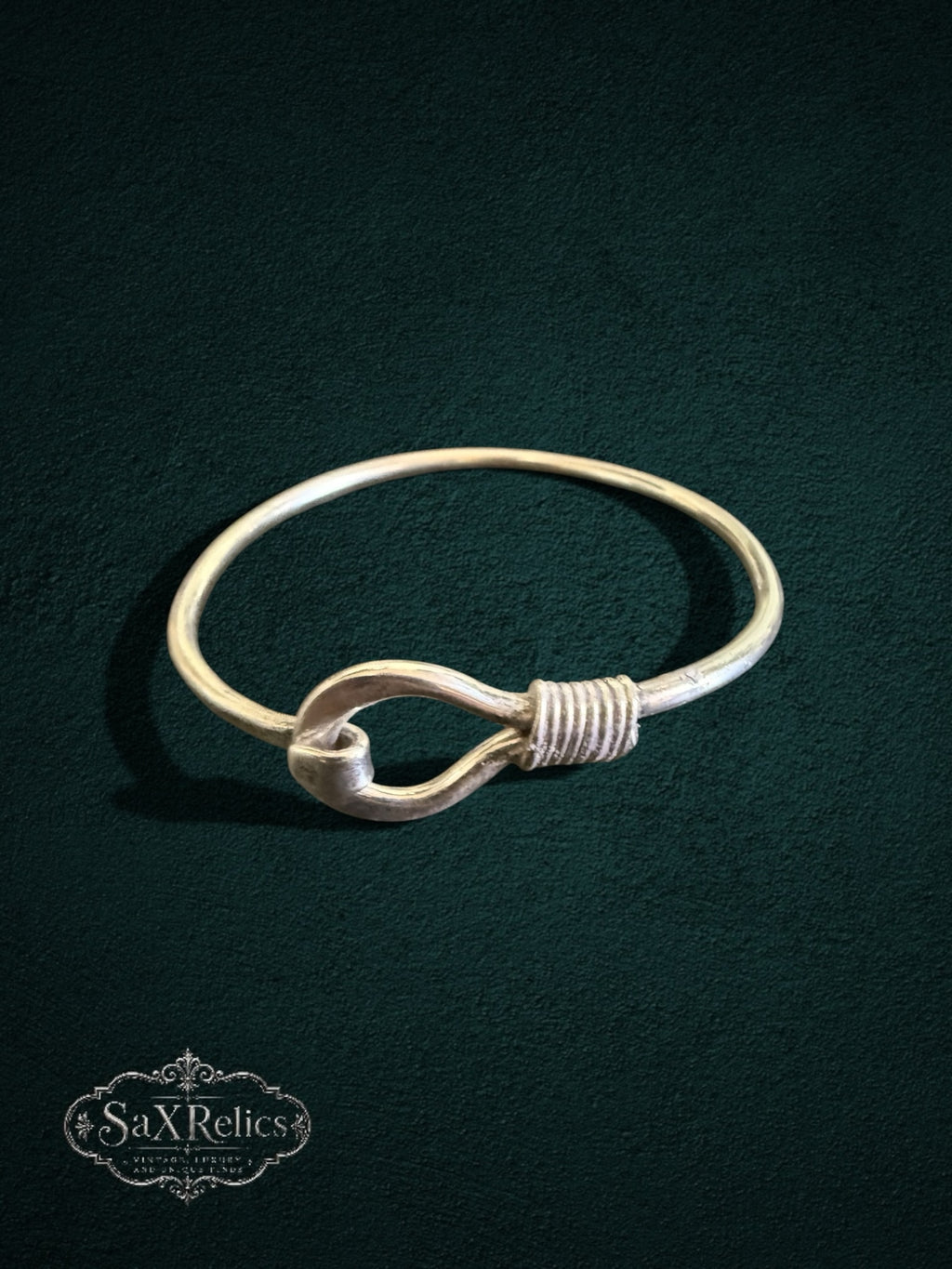 My Store SaxRelics sterling silver hook bangle bracelet with wire-wrapped detail on a dark textured background.