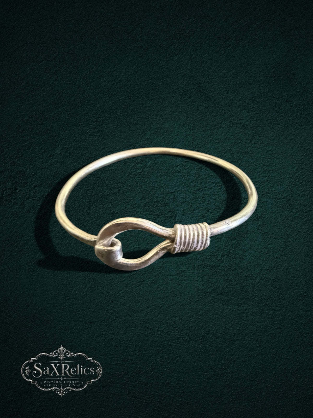 My Store SaxRelics sterling silver hook bangle bracelet with wire-wrapped detail on a dark textured background.