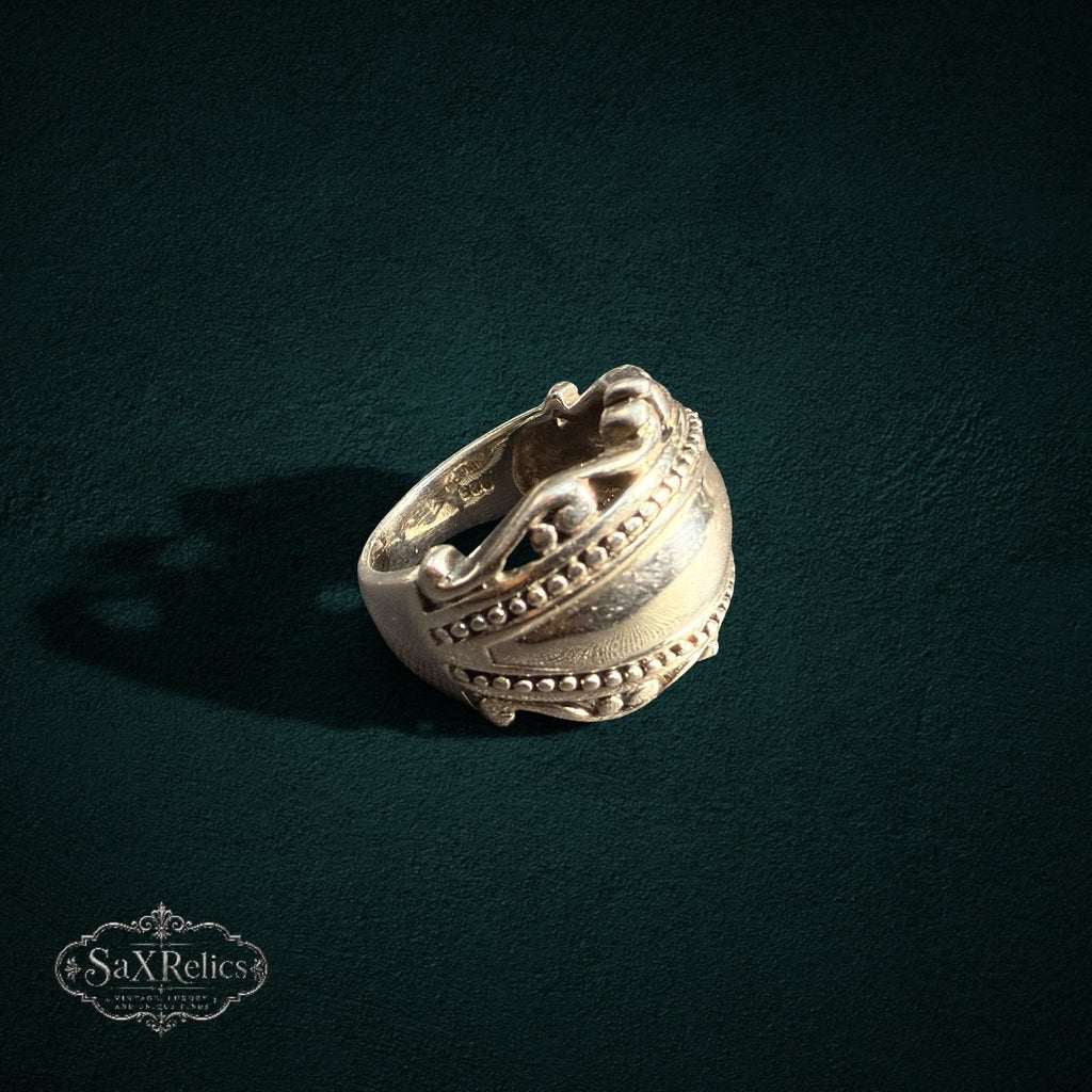 My Store SAXRelics sterling silver statement ring with polished dome, beaded borders, and intricate scrollwork detail.