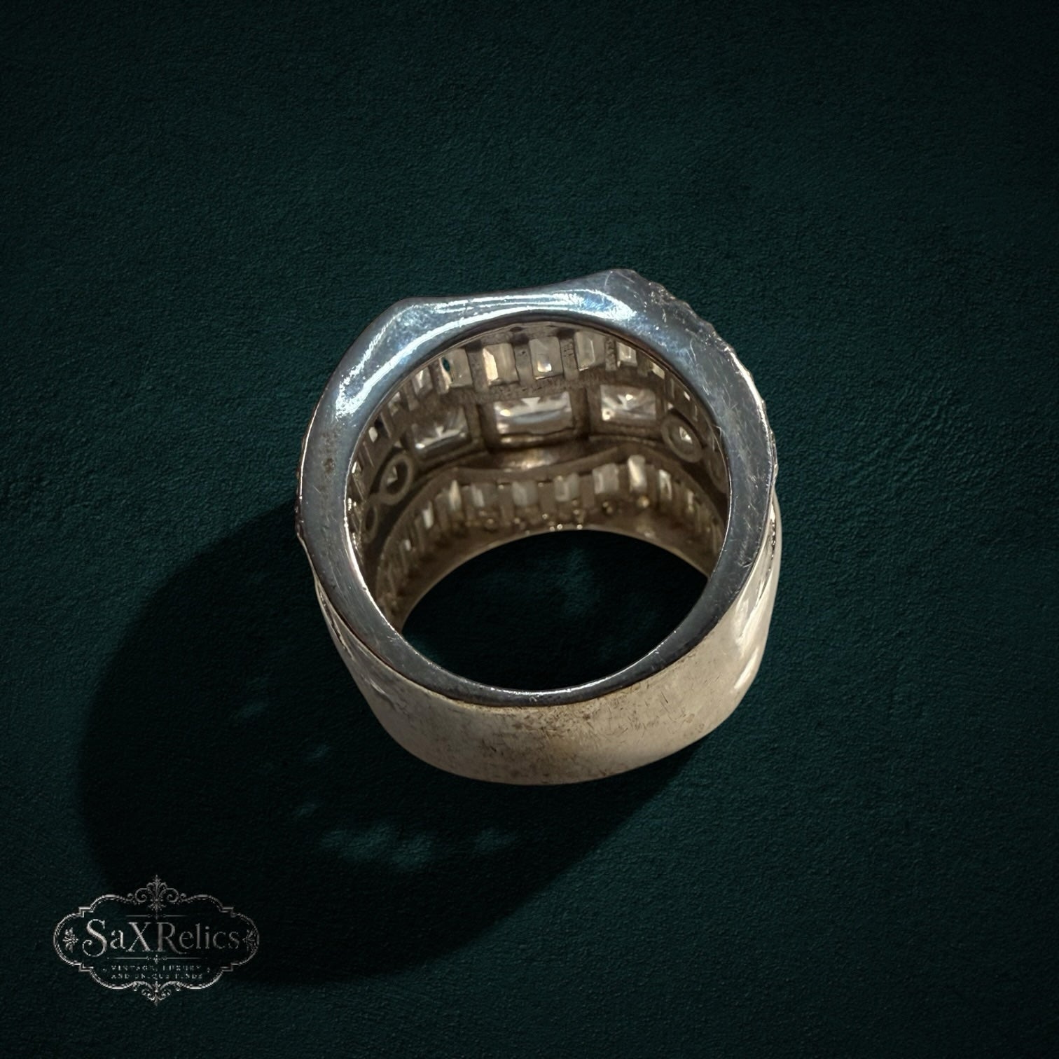 My Store SAXRelics wide sterling silver statement ring with baguette and round cut stones on a dark background