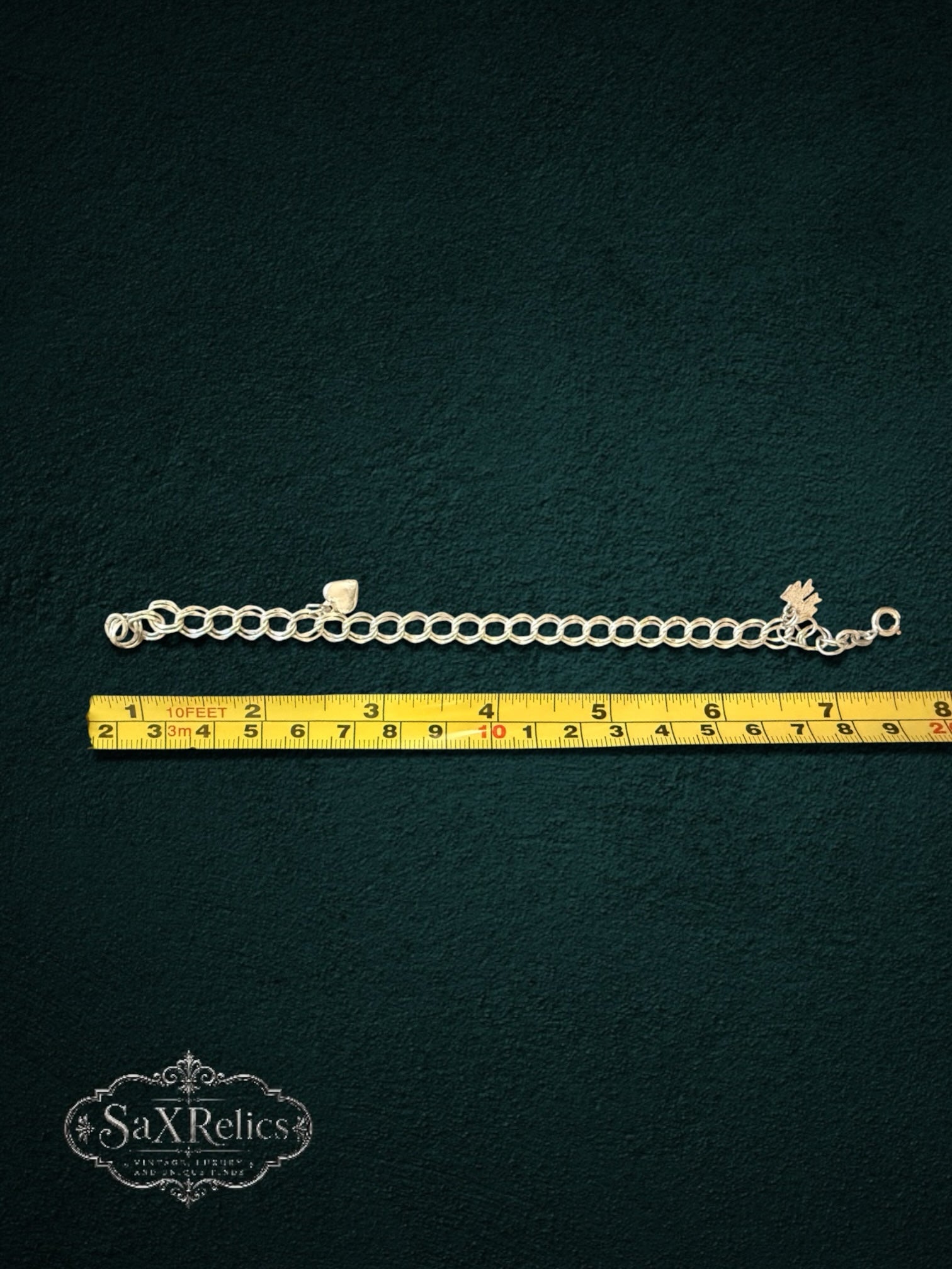 My Store SAXRelics vintage silver-tone charm bracelet with heart and floral charms measured against a yellow tape rule.