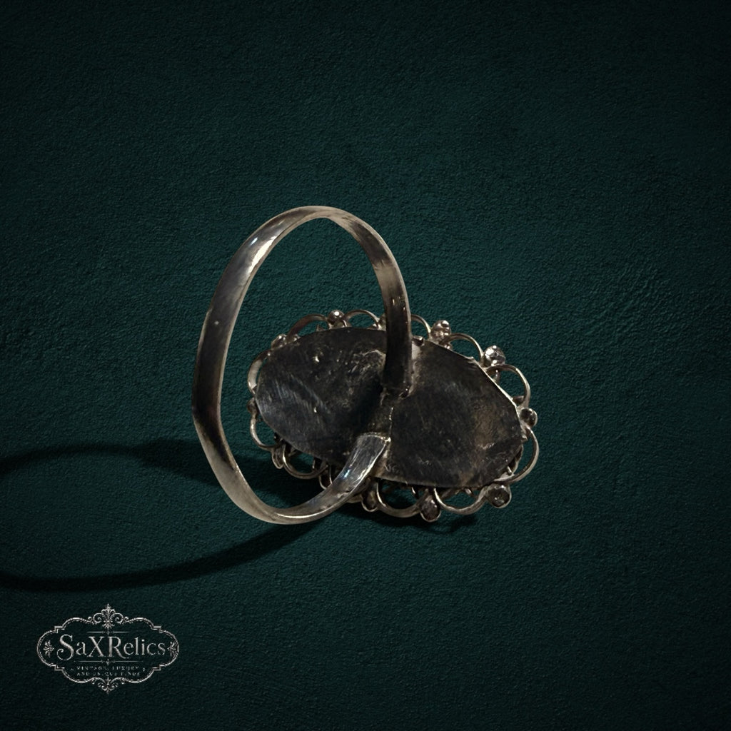 My Store SAXRelics vintage sterling silver ring showing the back of the oval filigree setting on a dark background.