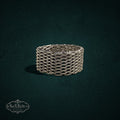 My Store SAXRelics silver-toned woven chain-link band ring with intricate chainmail texture on a dark background.