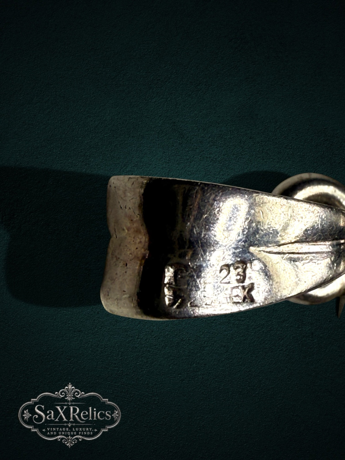 My Store vintage silver coin pendant bail detail showing hallmark stamps on a dark green background