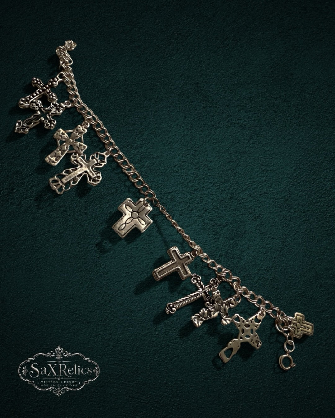 My Store SaxRelics silver-tone charm bracelet featuring various intricate cross pendants on a textured dark background