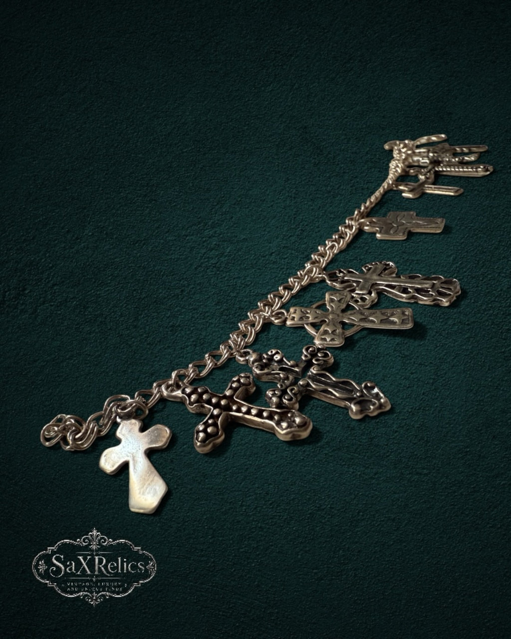 My Store SaxRelics silver-tone charm bracelet featuring diverse ornate and minimalist cross charms on a link chain