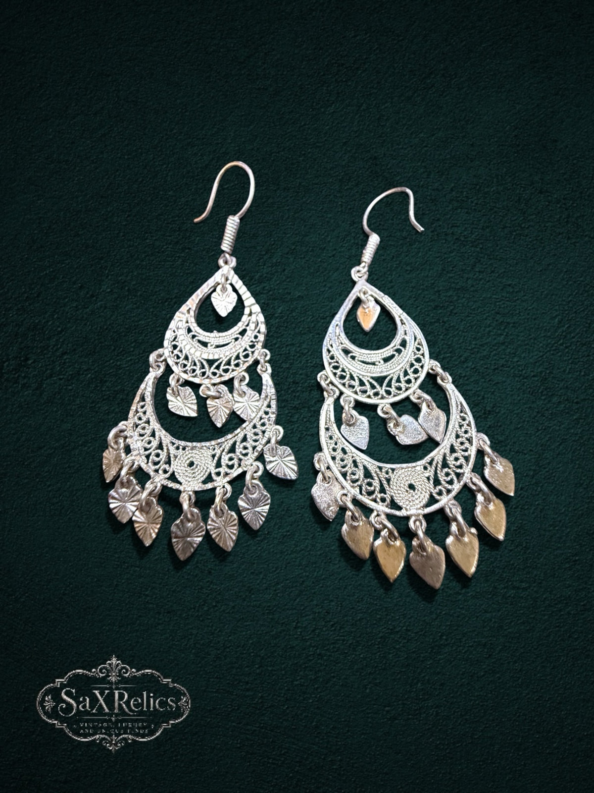 My Store SaxRelics silver-tone filigree teardrop chandelier earrings with dangling leaf charms on dark green background