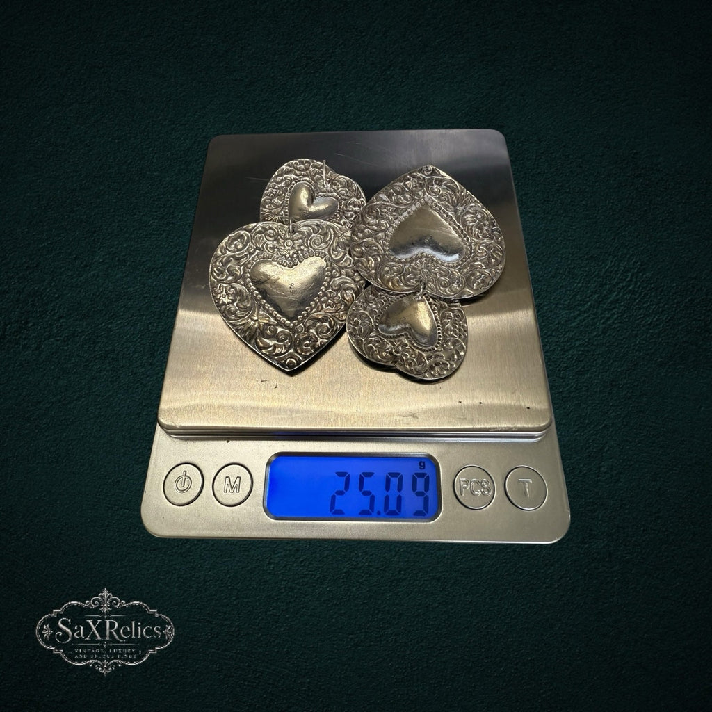 SaX Relics sterling silver 925 heart statement earrings on a digital scale showing 25.09 grams for the pair