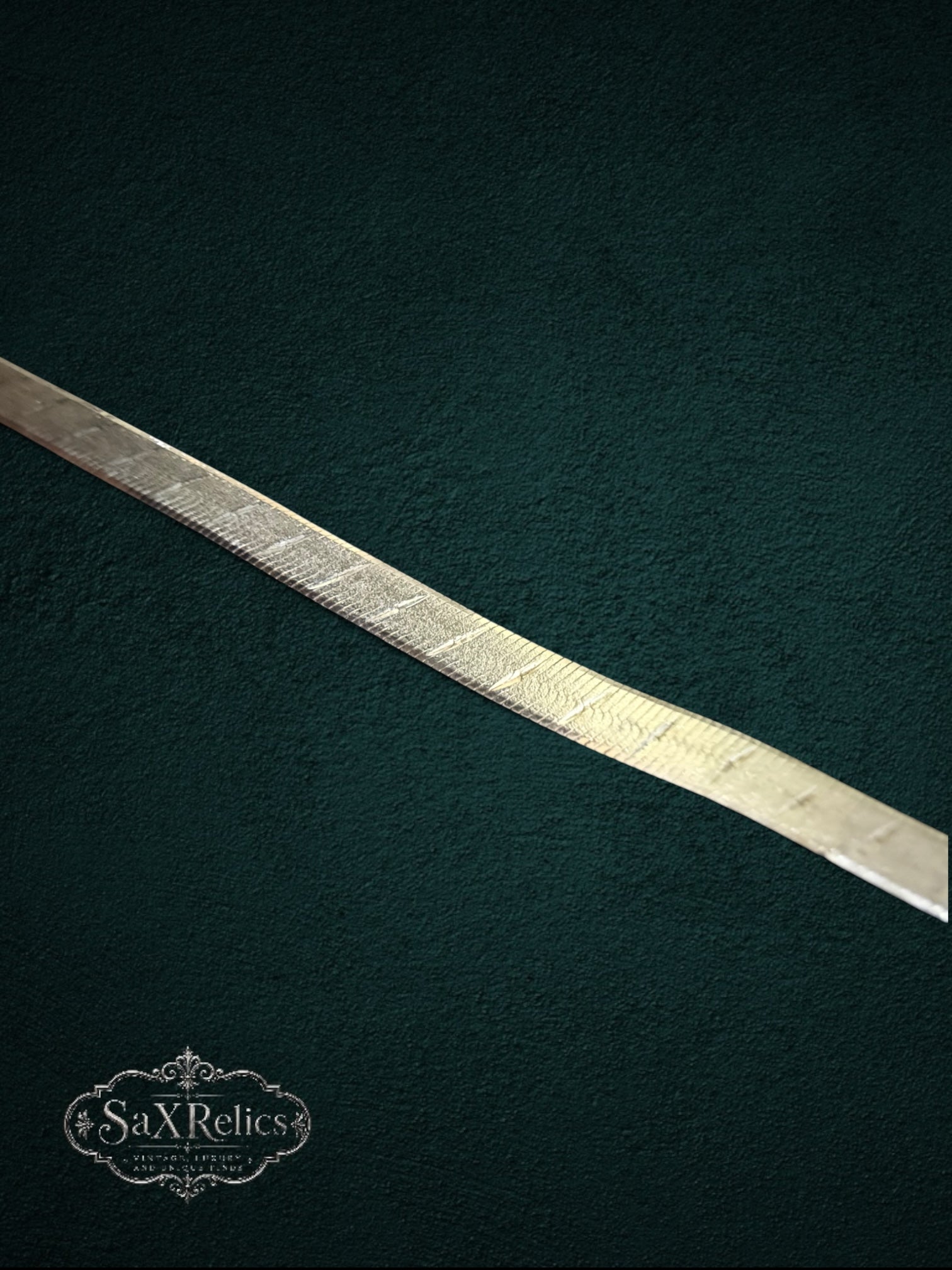 My Store silver-tone herringbone chain necklace with a diamond-cut crosshatch pattern on a dark textured background.