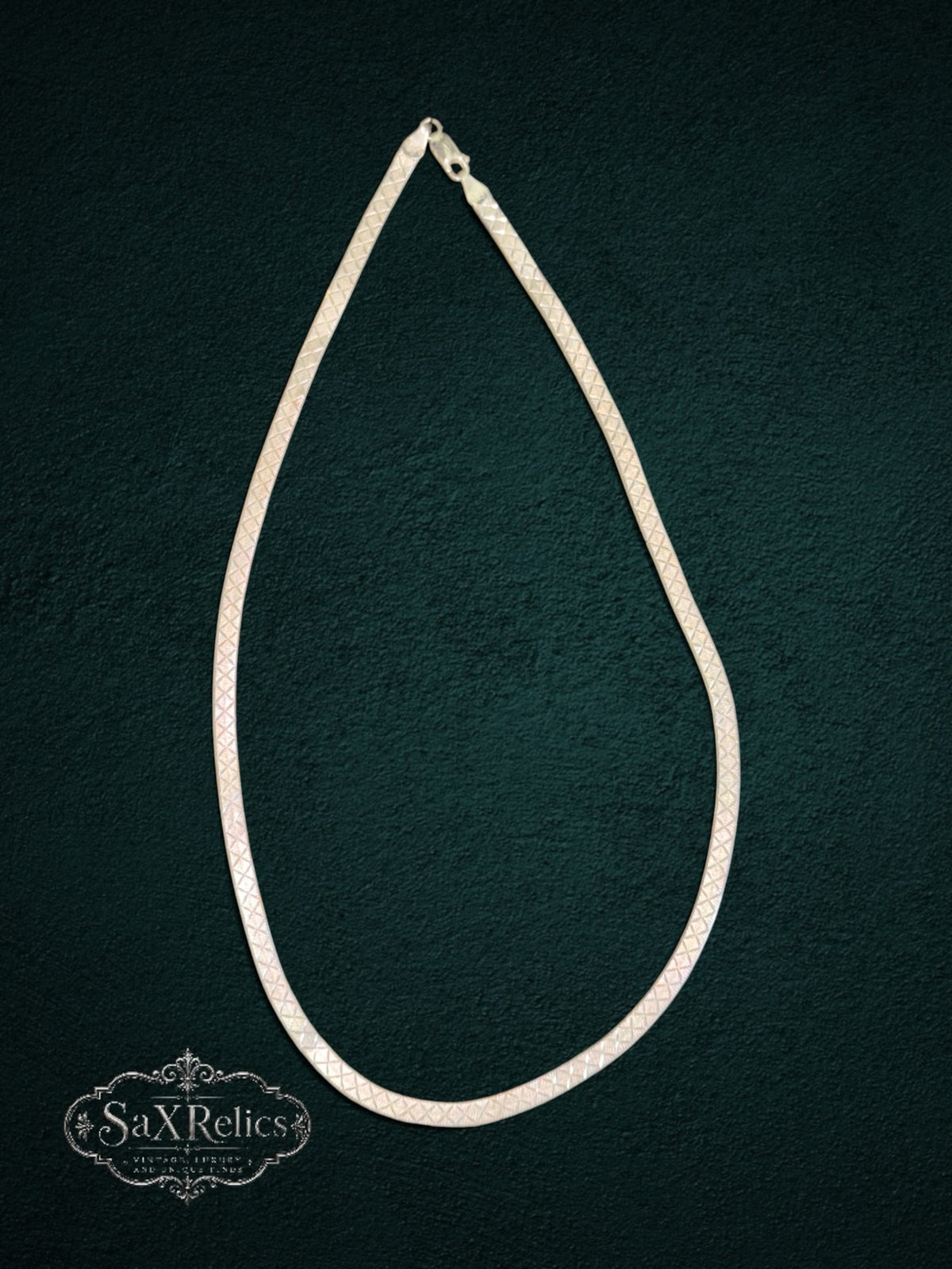 My Store silver-tone herringbone chain necklace with a diamond-cut crosshatch pattern on a dark textured background