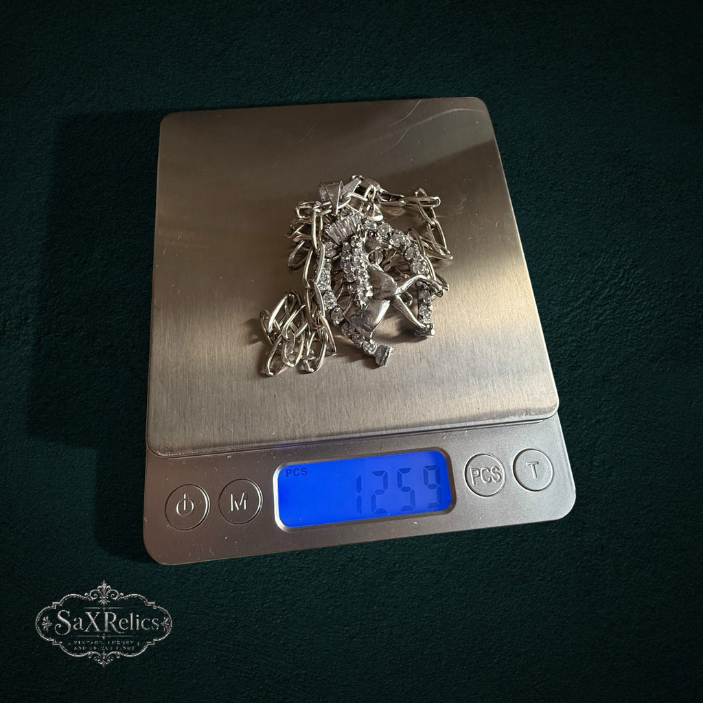 SaX Relics — Herradura sterling silver pendant necklace on a digital scale at 12.59 grams.