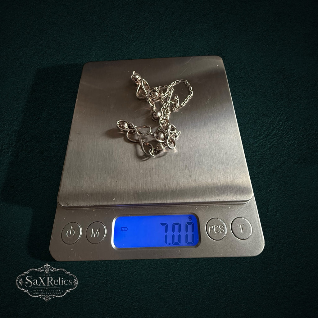 SaX Relics — Infinito sterling silver infinity-link necklace on a digital scale at 7.00 grams.