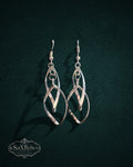 My Store SaxRelics silver-tone intertwined teardrop dangle earrings with a polished finish on a dark background
