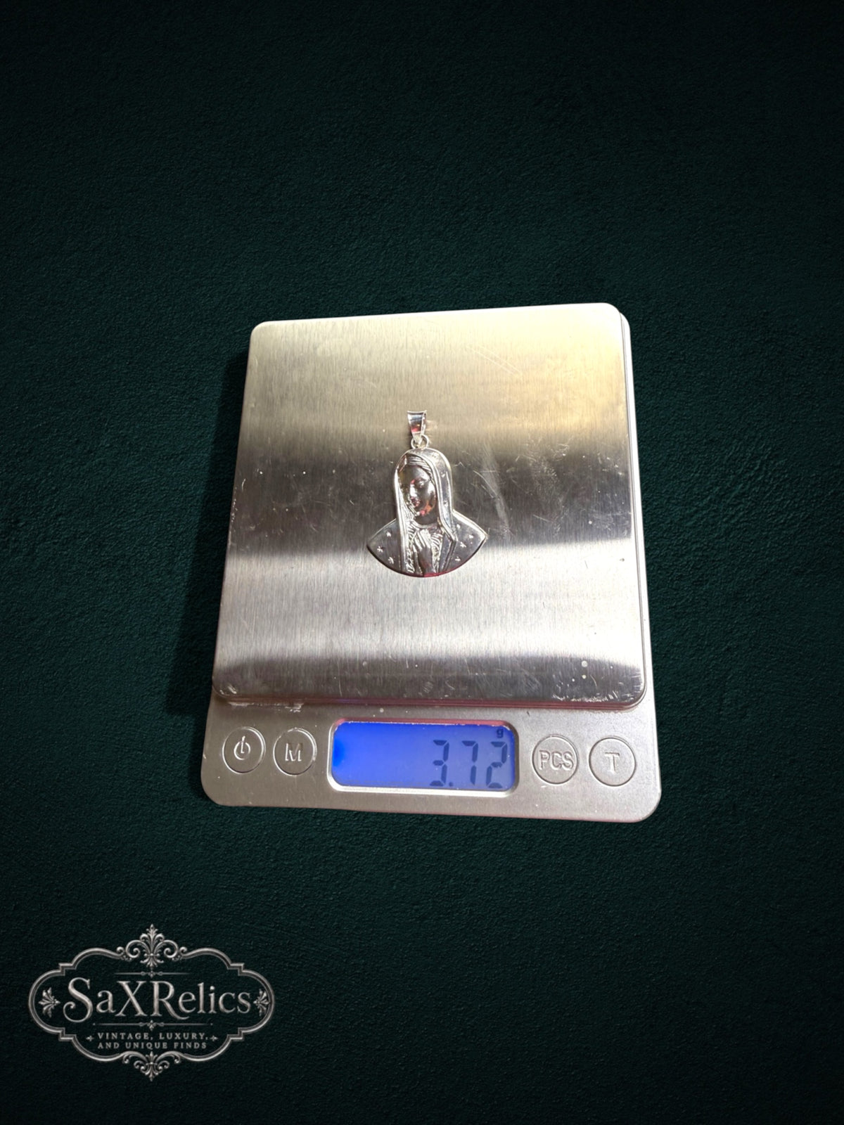 My Store silver Virgin Mary pendant with star details on a digital scale showing a weight of 3.72 grams