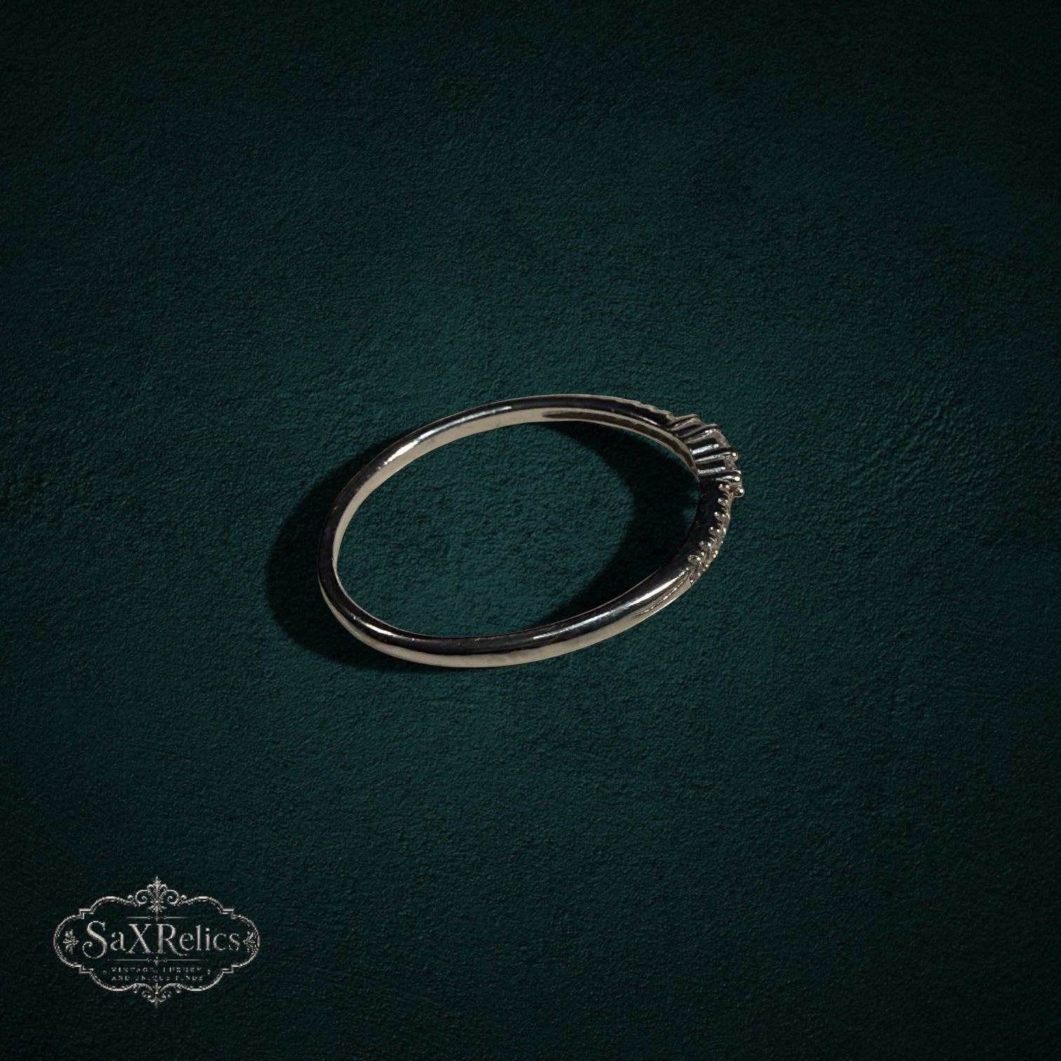 My Store delicate 925 sterling silver band ring with shimmering clear stones on a dark green textured background