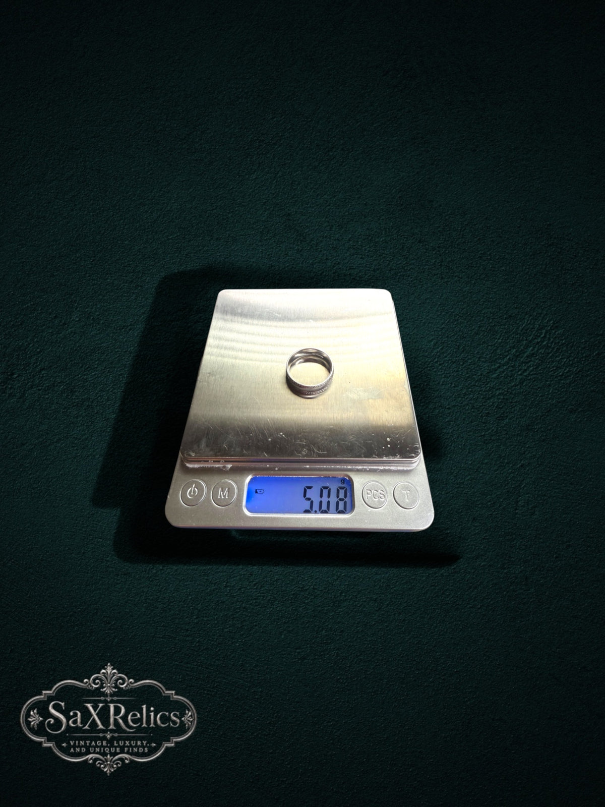 My Store sterling silver decorative band ring weighing 5.08 grams on a digital scale against a dark background
