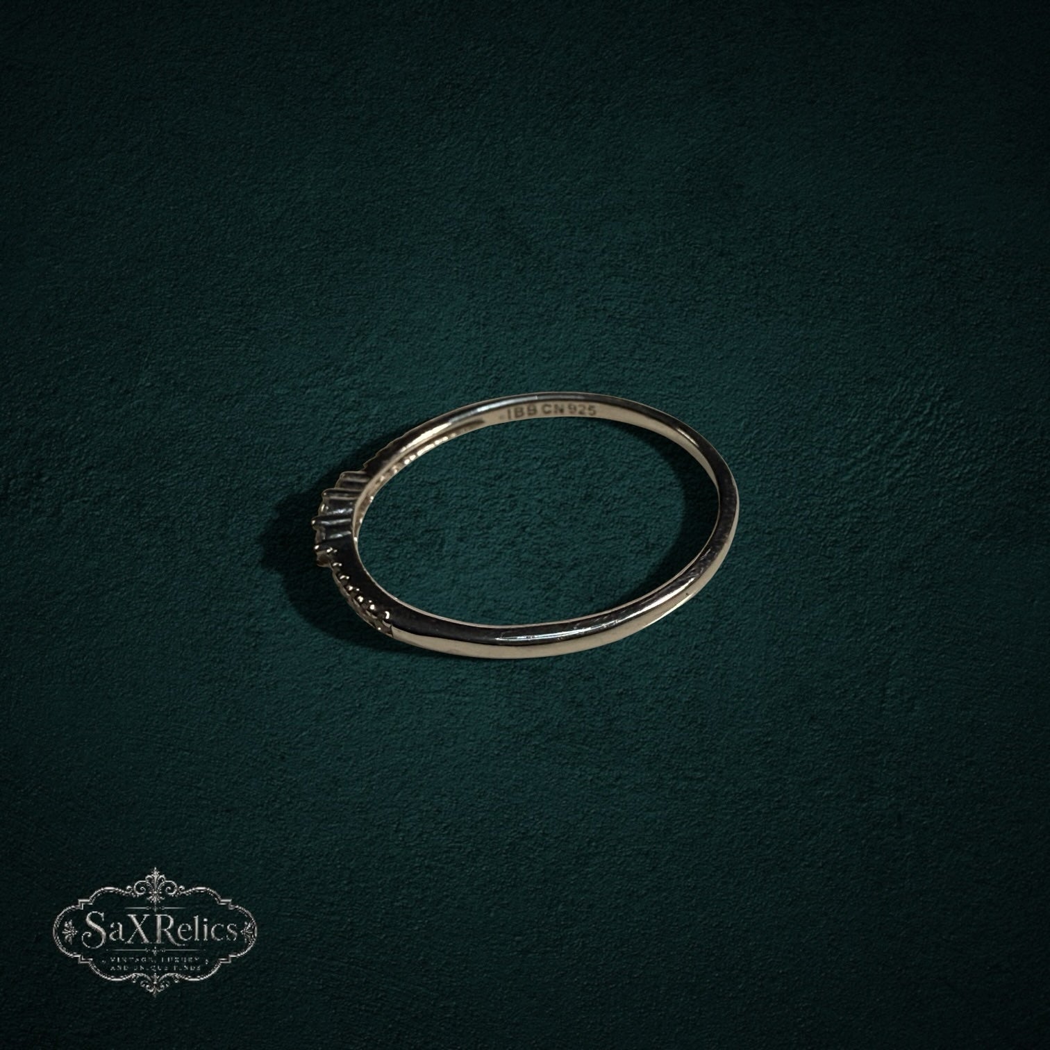 My Store delicate 925 sterling silver band ring with shimmering clear stones on a dark green textured background