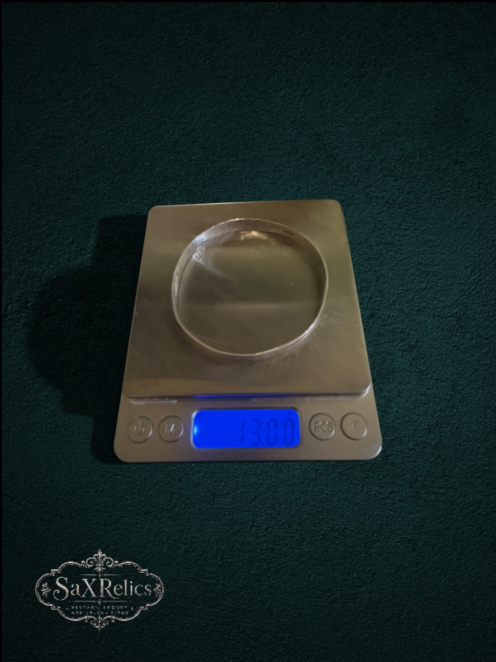 My Store handcrafted sterling silver bangle with hammered texture weighing 13 grams on a digital scale