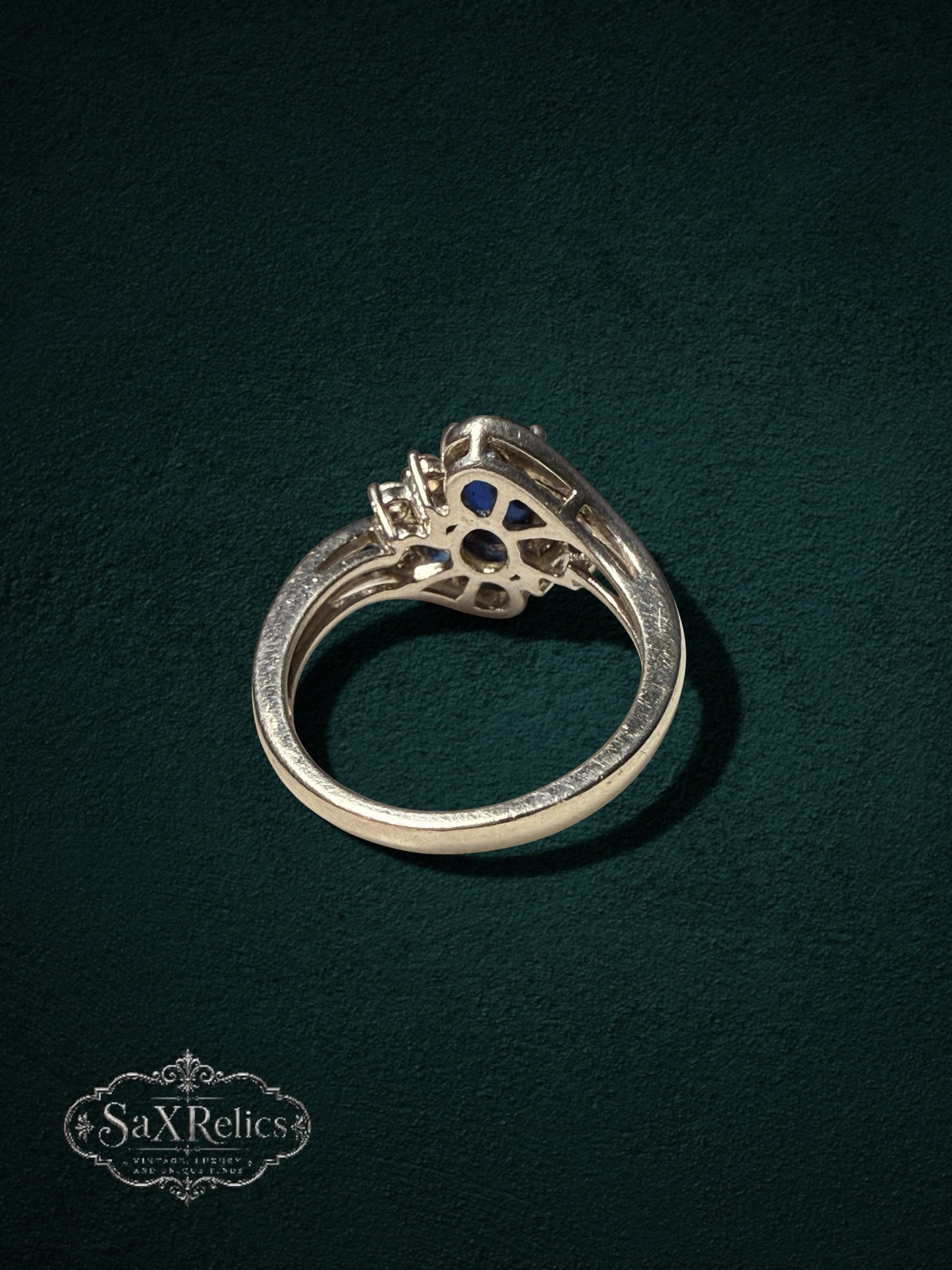 My Store sterling silver statement ring with a deep blue oval center stone and clear crystal accents on a dark background
