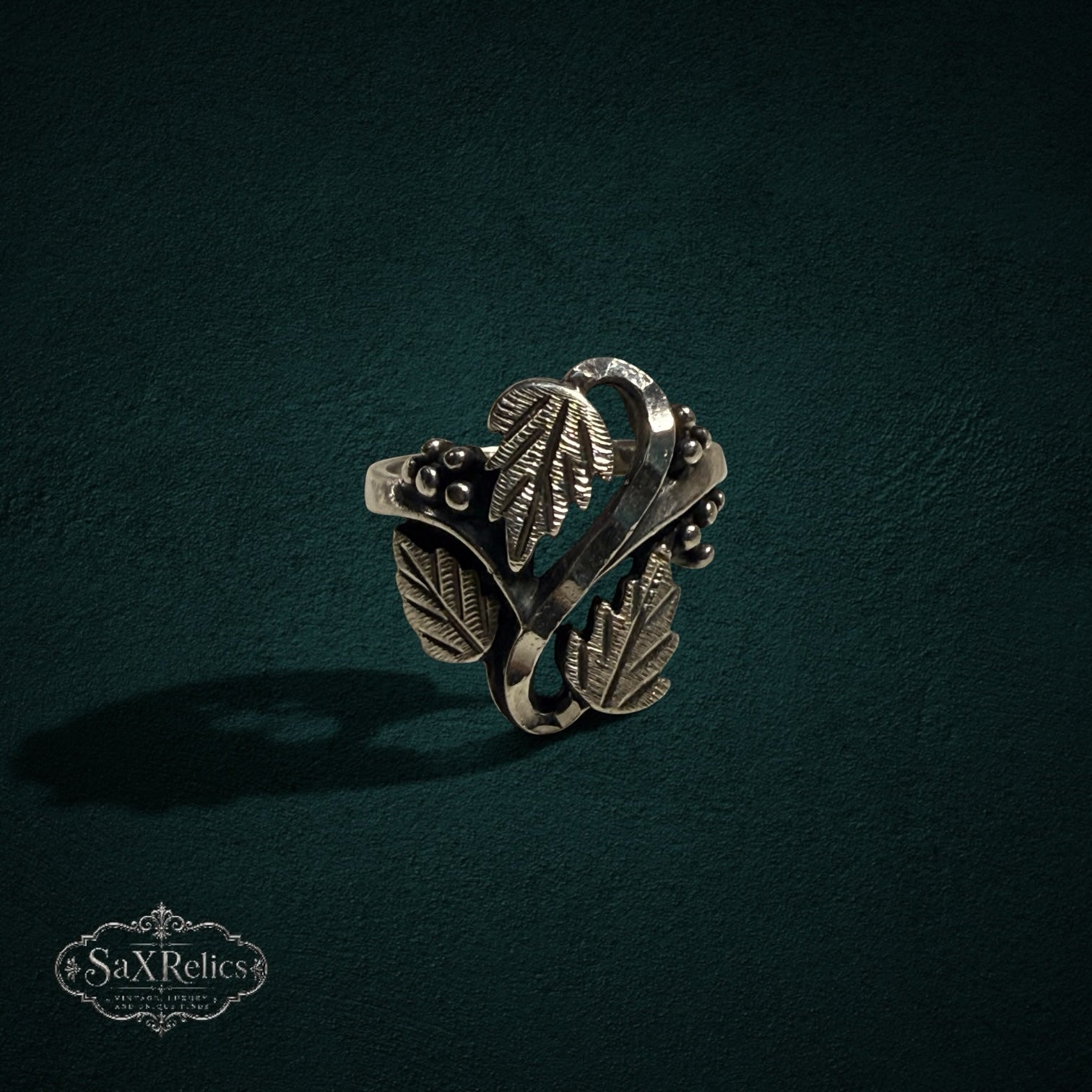 My Store SAXRelics sterling silver ring featuring an intricate botanical leaf and berry design with oxidized finish.
