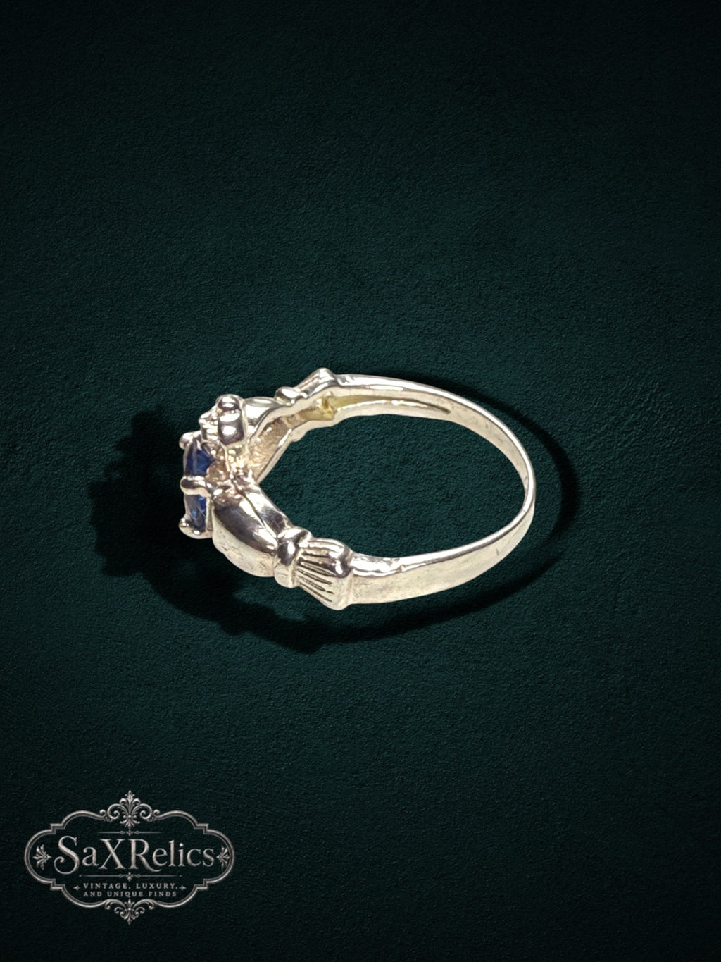My Store SAXRelics sterling silver Claddagh ring featuring a deep blue center stone and traditional heart motif.