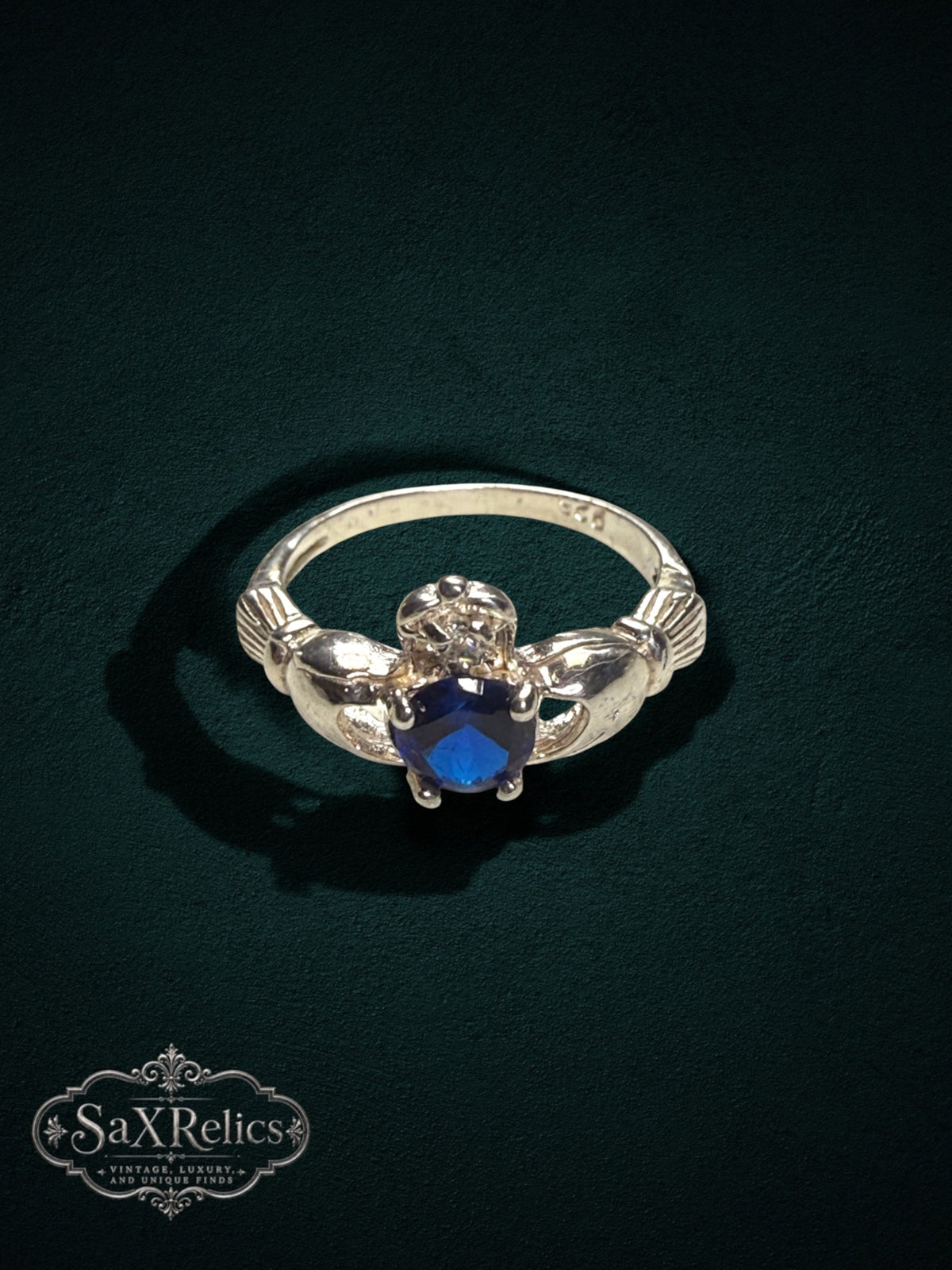 My Store SAXRelics sterling silver Claddagh ring featuring a vibrant blue center stone and iconic heart motif.