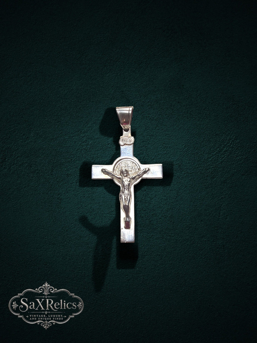 My Store sterling silver crucifix pendant featuring a detailed corpus and Saint Benedict medal on a dark background.