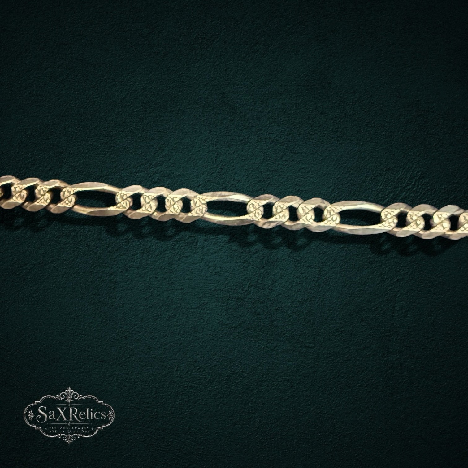 My Store 925 sterling silver Figaro chain bracelet with alternating circular and elongated oval links on dark background