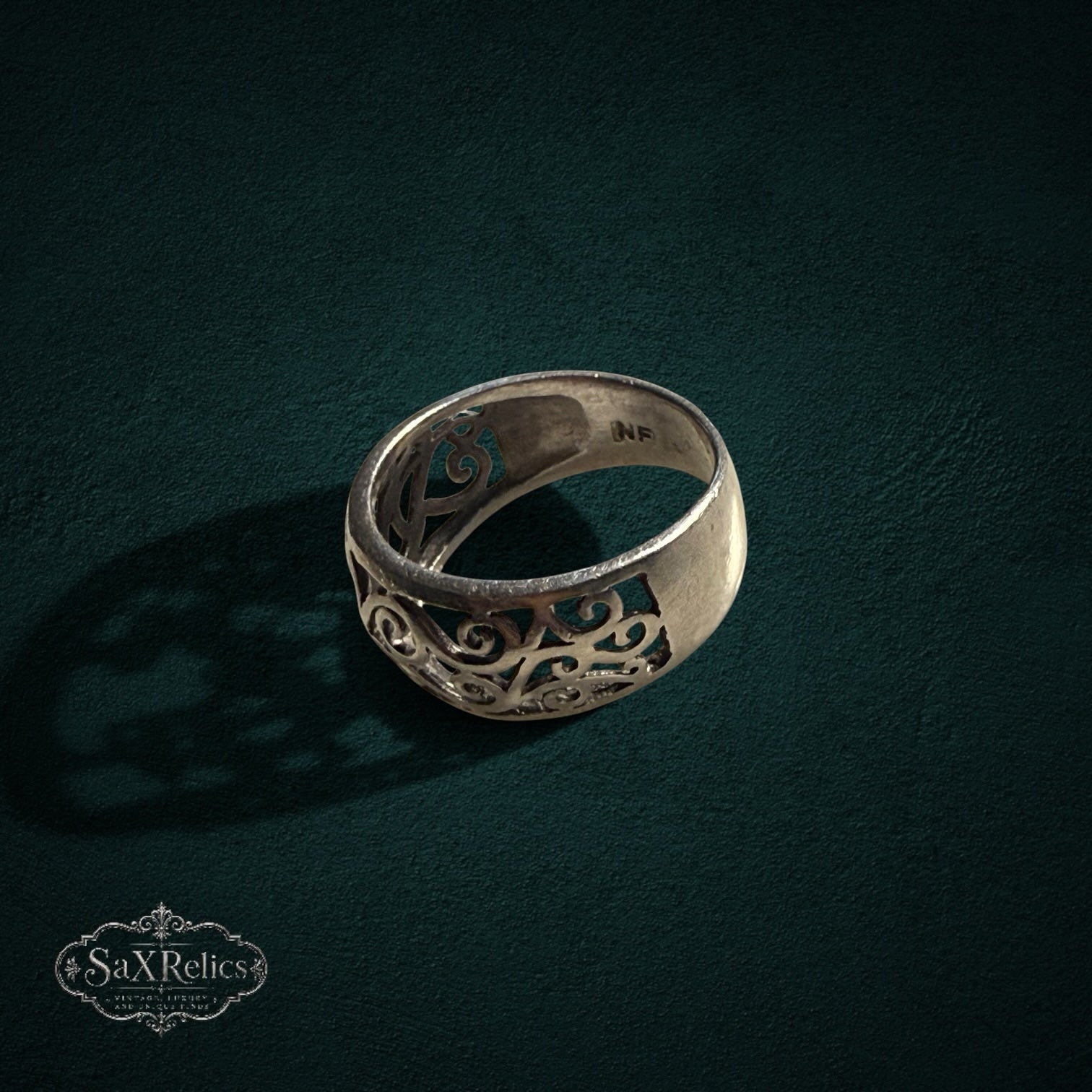My Store sterling silver band ring featuring an intricate openwork filigree scroll design on a dark textured surface