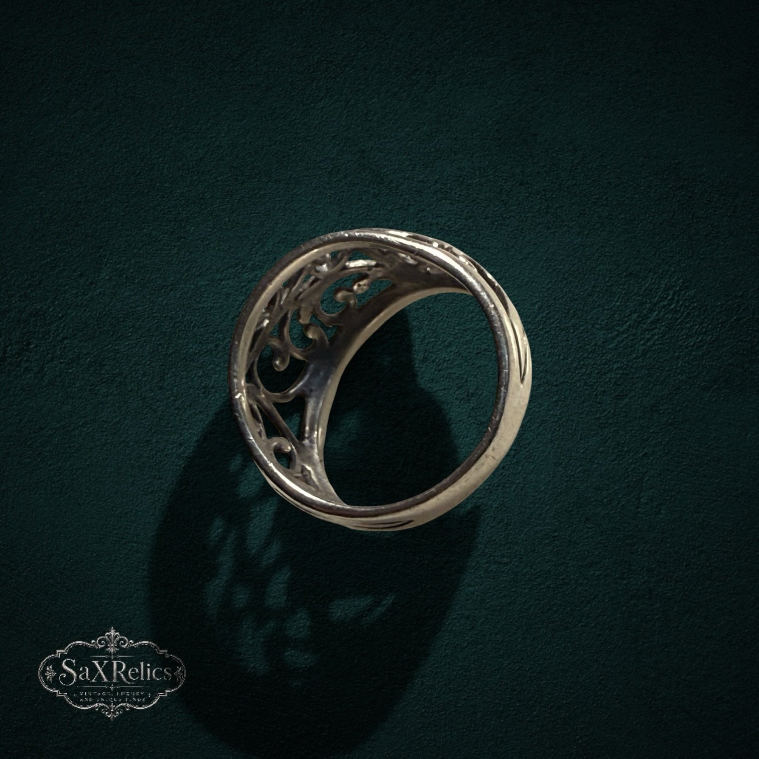 My Store SAXRelics sterling silver ring featuring intricate vintage-inspired filigree scrollwork on a dark background.