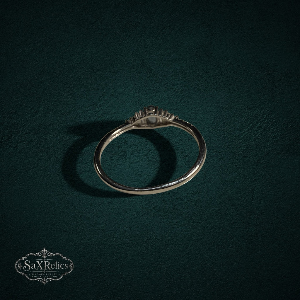 My Store sterling silver ring with central oval gemstone and baguette accents on a dark green background
