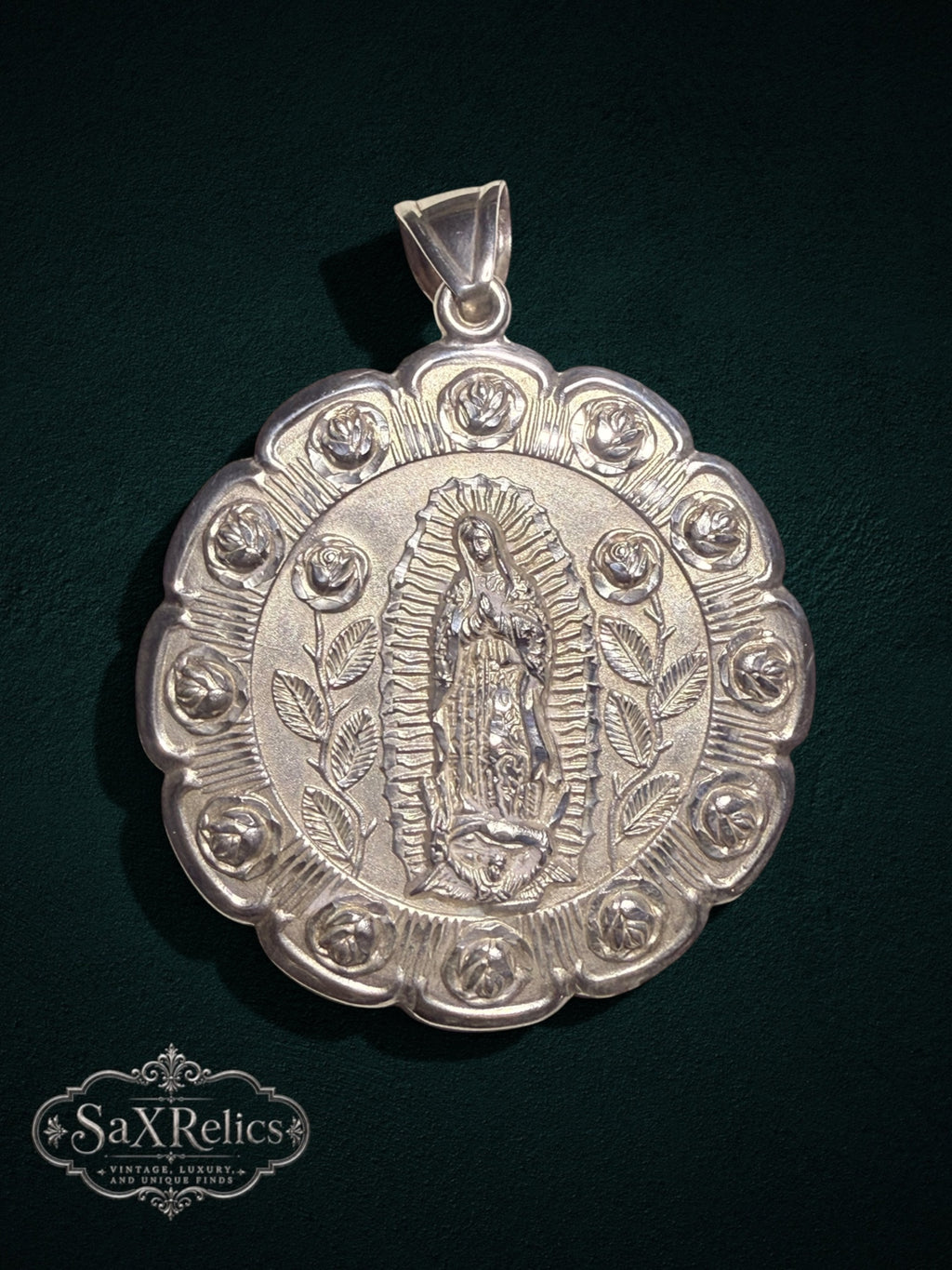 Sterling silver reversible pendant featuring the Virgin of Guadalupe with an ornate rose border.