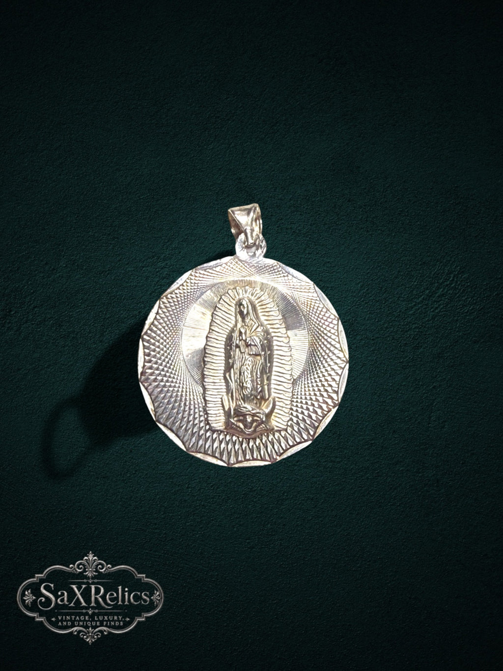 My Store sterling silver Our Lady of Guadalupe pendant with a detailed sunburst border on a dark green background.