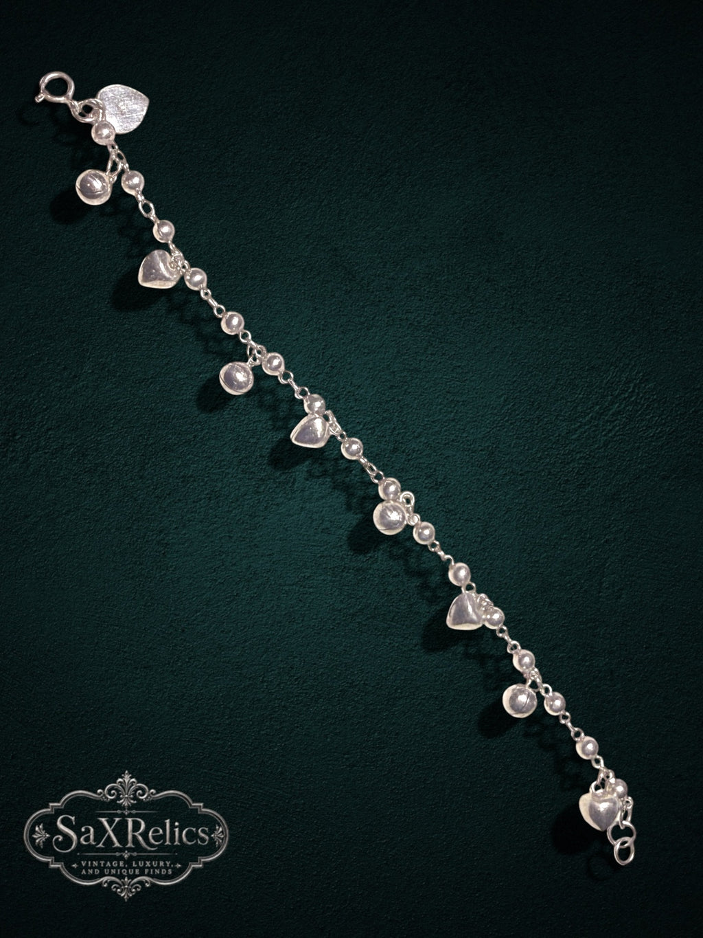 My Store SAXRelics sterling silver heart charm bracelet with polished spheres on a dark green background